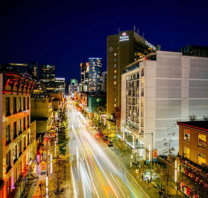 a city street at night with traffic and tall buildings