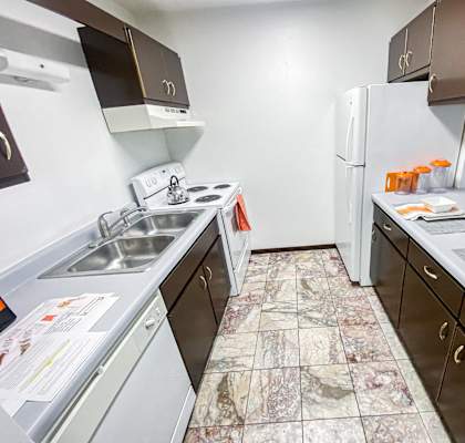 an empty kitchen with a sink and a refrigerator