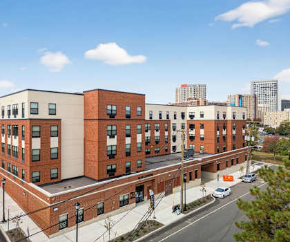 A large red brick building with a parking lot in front.