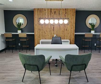 Two green chairs are in front of a white table.