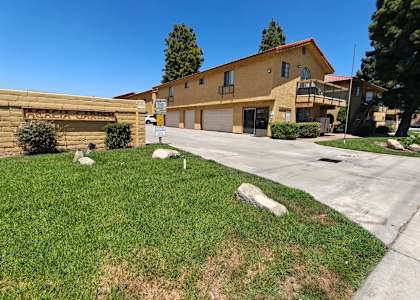 A yellow house with a garage and a driveway in front.