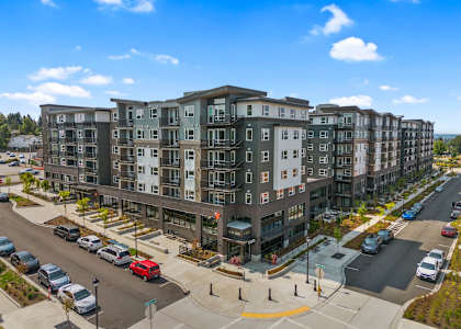 A large apartment building with a parking lot in front.