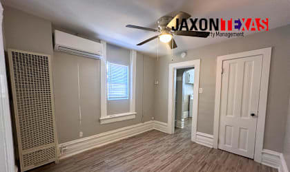 A room with wooden flooring and a ceiling fan.