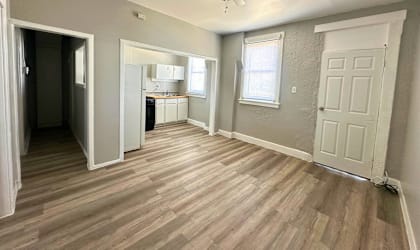 A room with a ceiling fan and wooden flooring.