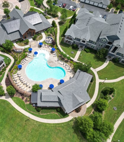an aerial view of a large swimming pool in a neighborhood with houses