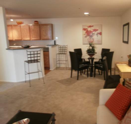 a living room and kitchen with a dining room table and chairs