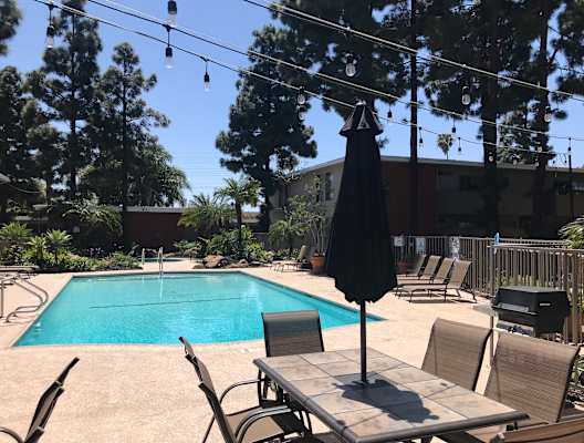 a swimming pool with a table and chairs around it