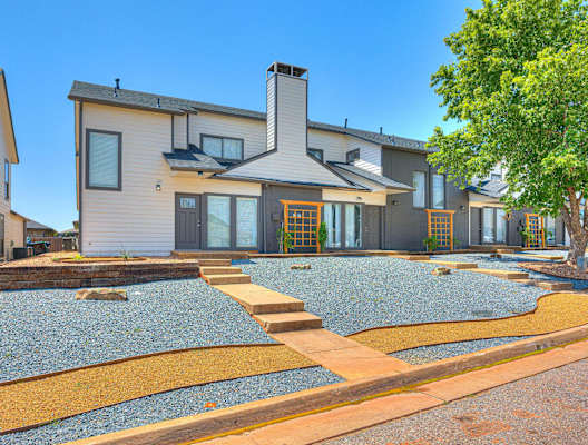 the front of a house with a gravel yard and a tree at Diamond Ridge Townhomes, Oklahoma ,73114