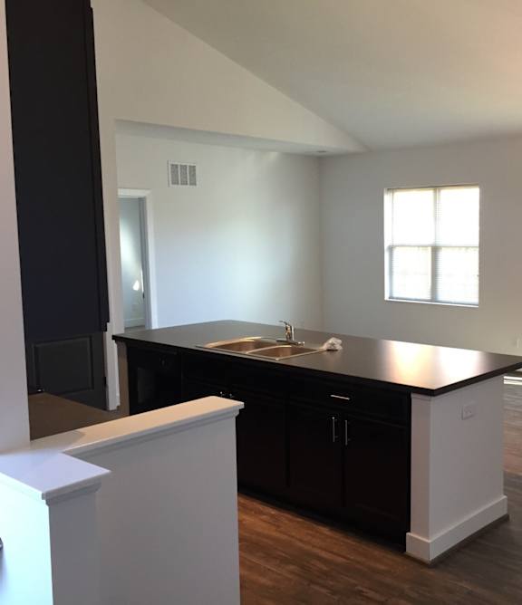 A kitchen with black cabinets and a white island at River View at Bexley Apartments, Ohio 43209