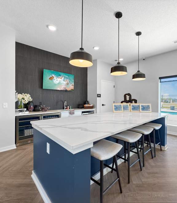 A kitchen with a long island and bar stools. at Rialto Townhomes Apartments, Waukee, Iowa