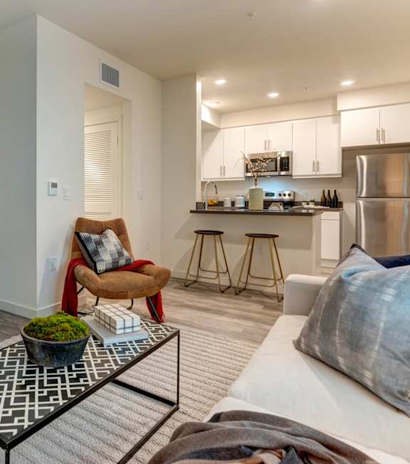 A living room with a white sofa, a black and white coffee table, and three framed pictures on the wall.