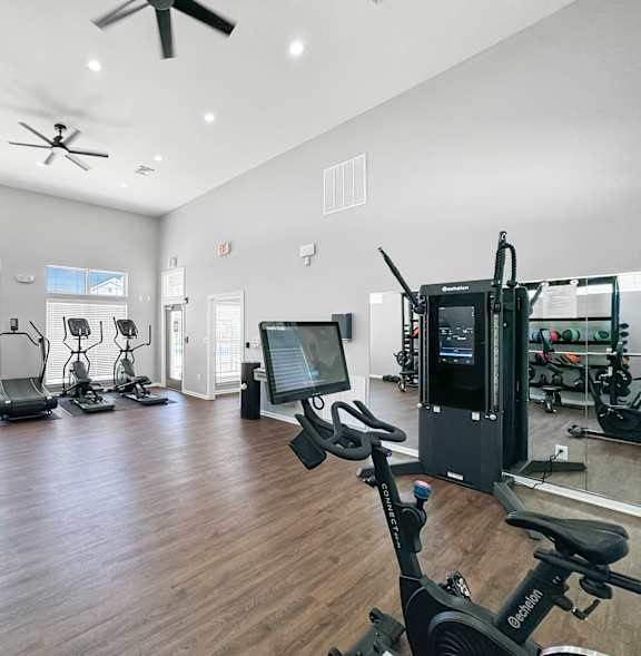 A spacious gym with a variety of equipment including treadmills, stationary bikes, and weight machines.at 92West, West Des Moines, IA