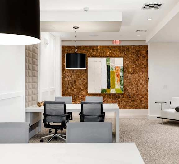 A modern office space with a wooden accent wall and black chairs.