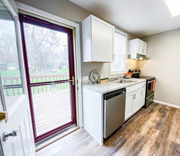 a small kitchen with a sliding glass door leading to a patio