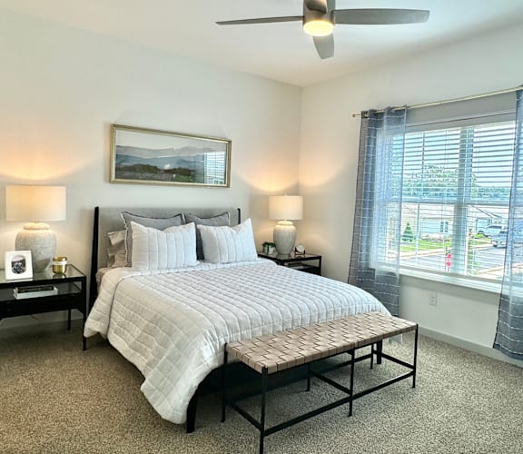 A bedroom with a large bed and a ceiling fan.