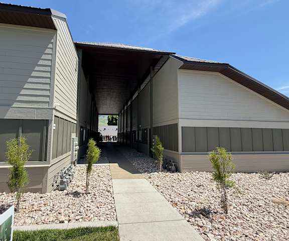 A modern building with a gravel pathway leading to the entrance.