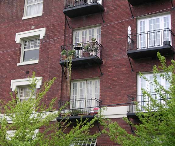 A red brick building with white trim and black balconies.