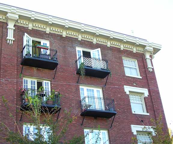 A red brick building with balconies on the second floor.