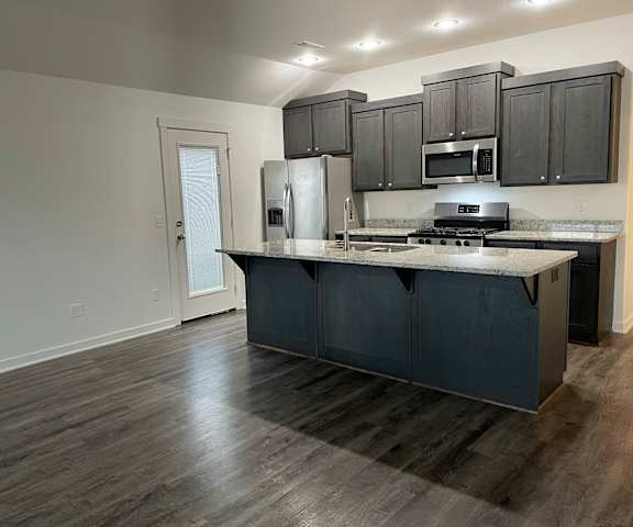 a kitchen with a large island and stainless steel appliances