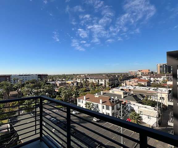 a balcony with a view of the city and palm trees