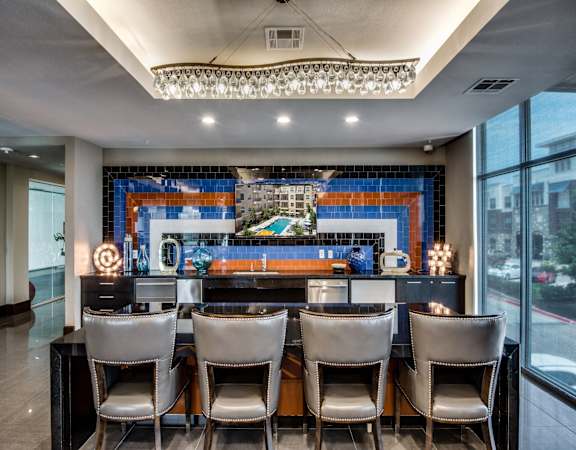 a long bar with chairs in front of a window