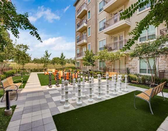 a large chess set in front of an apartment building