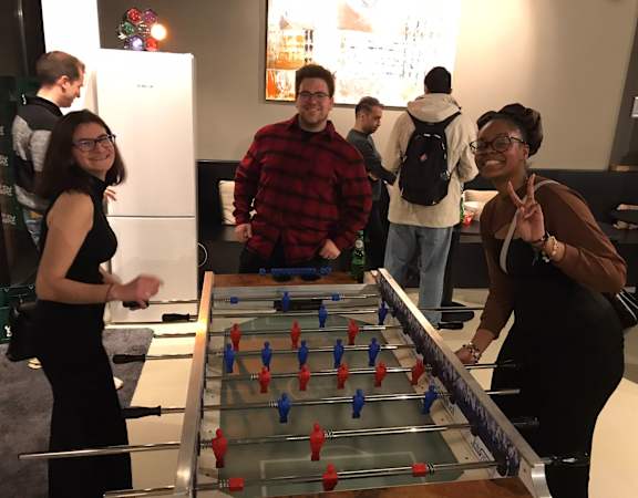 A group of people playing a game of foosball.