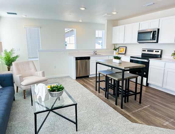 a living room with a kitchen and a table with chairs