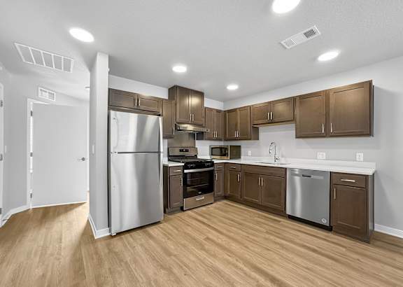 A kitchen with wooden floors and stainless steel appliances.at Hawthorne Pointe, Bondurant, 50035