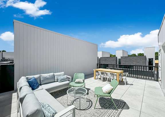 a rooftop patio with a couch and chairs and a table at Matilda 235 Townhomes, Des Moines, 50309