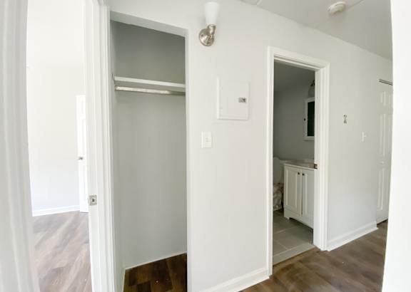 a bedroom with white walls and a wooden floor