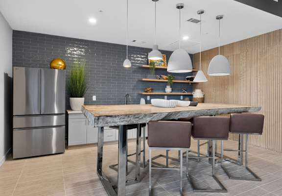 A modern kitchen with a marble table and stainless steel appliances.