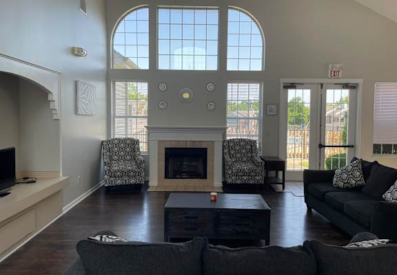 A living room with a fireplace and two chairs.