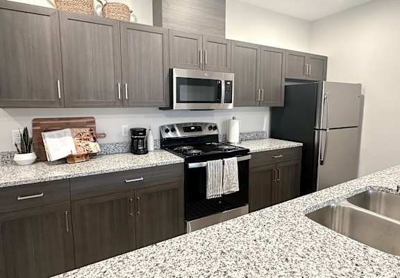 A kitchen with a black stove top oven and a black refrigerator.