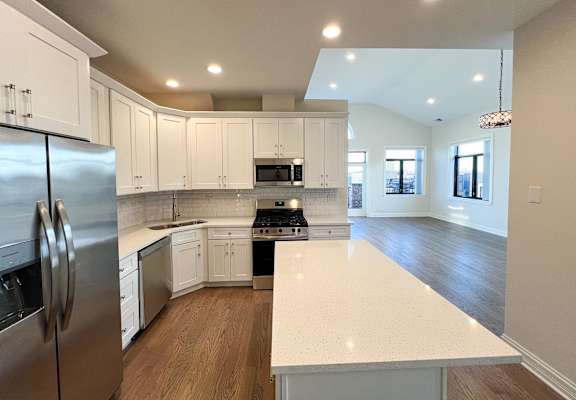 Kitchen at Highpoint West Town apartments in Chicago with white cabinets, stainless steel refrigerator, and contemporary design