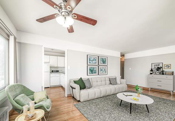 Bright living room at Clarendon Shores apartments in Uptown Chicago featuring hardwood floors, modern furniture, and large picture windows.