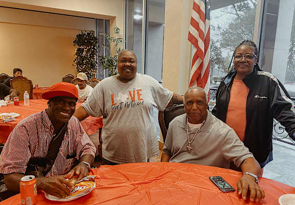 people sitting at a table with plates of food