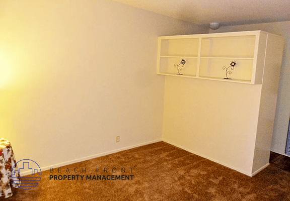 an empty room with a shelf on the wall