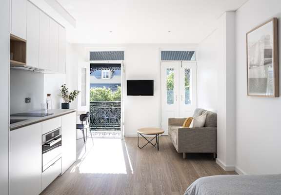 a kitchen and living room with a door to a balcony