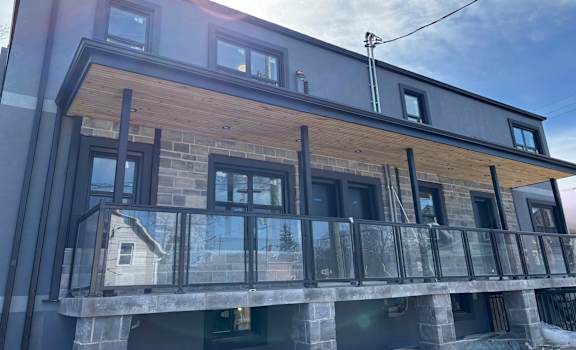 A modern house with a balcony and a glass railing.