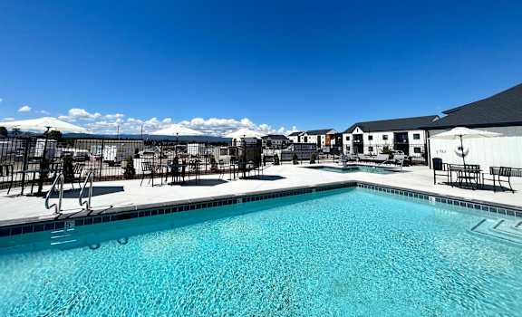 A swimming pool with a blue sky and some clouds in the background at Silverbrook Apartments Apartments, Kalispell, 59901
