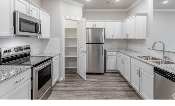 a kitchen with white cabinetry and granite countertops