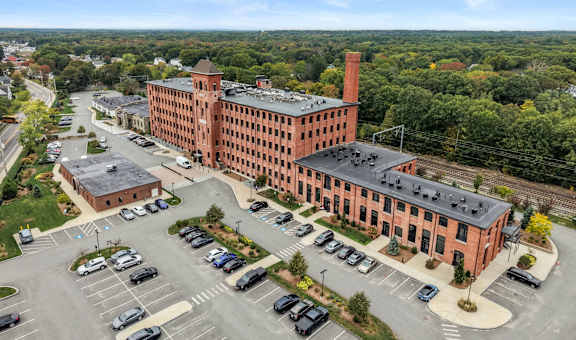 A large red brick building with a parking lot in front.