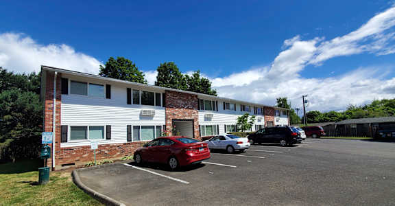 A parking lot with cars and a building in the background.