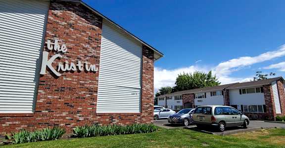 The Kristin House is a residential building with a brick wall and a sign on it.