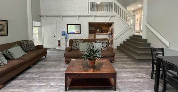 A living room with a brown couch and a wooden coffee table.
