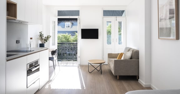 a kitchen and living room with a door to a balcony