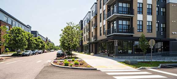 A modern apartment building with a landscaped median in front of it.
