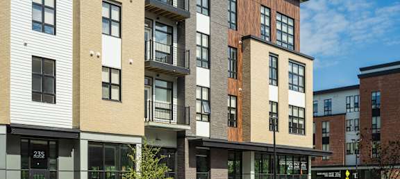A modern apartment building with balconies and multiple floors.
