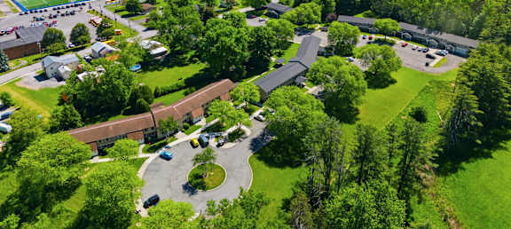 A bird's eye view of a residential area with a large green field and a building.